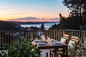 a wooden table on a balcony with a view of the ocean at Allure Lodge in Paihia