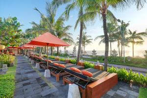 a row of benches with the beach in the background at Legian Beach Hotel in Legian
