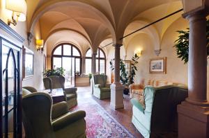 a waiting room with chairs and tables in a building at Palazzo Leopoldo Dimora Storica & Spa in Radda in Chianti