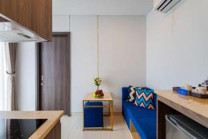 een woonkamer met een blauwe bank en een tafel bij Aurora Western Village in Ho Chi Minh-stad