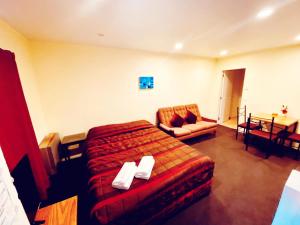 a hotel room with a bed and a chair at Baden Lodge in Rotorua