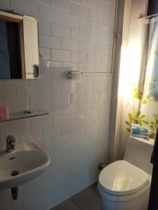 a white bathroom with a toilet and a sink at Historical townhouse in city center in Tainan
