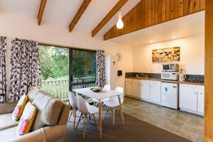 a kitchen and living room with a table and chairs at Allure Lodge in Paihia