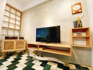 sala de estar con TV de pantalla plana en la pared en 歸宿back home en Tainan