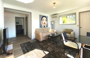 een woonkamer met een bank en een schilderij van een gezicht bij Apartment at Floras Lake Getaway in Langlois