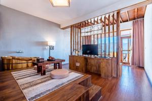 uma sala de estar com uma televisão e uma mesa em The Corner Seaview Hotel em Dali