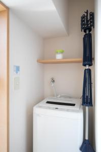 eine Waschmaschine mit zwei Fingerspitzen darüber in der Unterkunft Comfort CUBE PHOENIX S KITATENJIN in Fukuoka