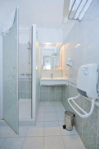 uma casa de banho com um chuveiro e um lavatório. em Azur Hotel em Balaruc-les-Bains
