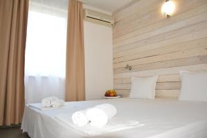 Un dormitorio con una cama blanca con toallas. en Milennia Family Hotel en Sunny Beach