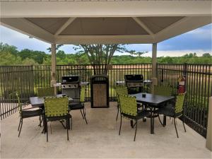 a patio with tables and chairs and a grill at Candlewood Suites Macon by IHG in Macon
