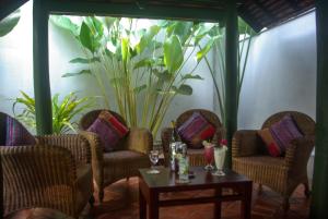 - un groupe de chaises et une table dans une pièce dans l'établissement Villa Maydou Boutique Hotel, à Luang Prabang