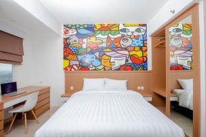 a bedroom with a bed and a painting on the wall at Urban Express HomTel - Serpong in Banten