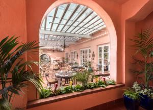 a restaurant with an arched window and tables and chairs at La Valencia Hotel in San Diego