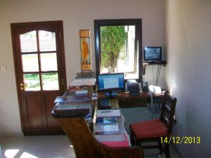 Zimmer mit einem Schreibtisch und einem Computer darauf in der Unterkunft Raices del Carolino - Suites de Altagracia in Alta Gracia