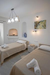 sypialnia z 2 łóżkami i obrazem na ścianie w obiekcie Ioanna's House w mieście Mykonos