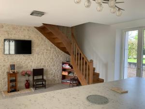 a living room with a staircase and a table at Le Gite du Chemin Vert in Pontlevoy