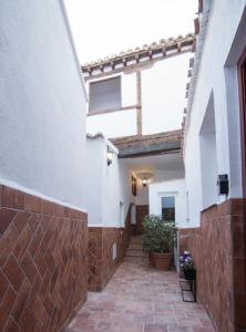 un couloir d'un bâtiment avec une passerelle en briques dans l'établissement Bajo Izq, à Tolède