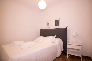 une chambre avec un lit blanc avec deux serviettes dessus dans l'établissement Bajo Izq, à Tolède