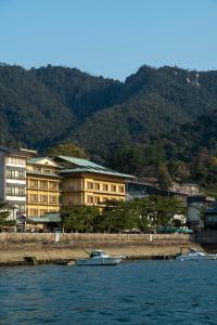dos barcos en el agua frente a los edificios en Hotel Miya Rikyu en Miyajima