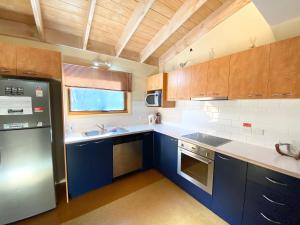 a kitchen with blue cabinets and a sink and a refrigerator at Snowdragon in Dinner Plain