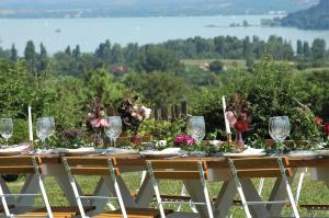 una mesa de madera con copas de vino y flores. en Koczor Winery & Guesthouse en Balatonfüred