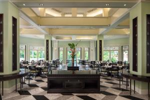 un salón de banquetes con mesas y sillas en una habitación en Dheva Mantra Resort, en Kanchanaburi