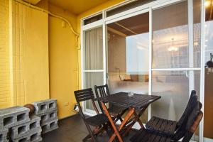 a table and chairs on a balcony with a window at Forever Sunny B&B in Ruifang