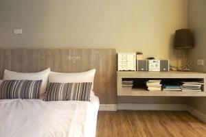 1 dormitorio con cama y estante con libros en Forever Sunny B&B en Ruifang