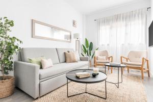 uma sala de estar com um sofá e duas mesas e cadeiras em Cool Apartments by Olala Homes em Madrid