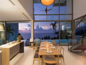 ein Esszimmer mit Tisch und Blick auf das Meer in der Unterkunft Malaiwana Residences in Nai Thon Beach