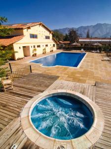 una bañera de hidromasaje en una terraza de madera junto a una casa en Howard Johnson Hotel Rinconada de Los Andes, en Los Andes