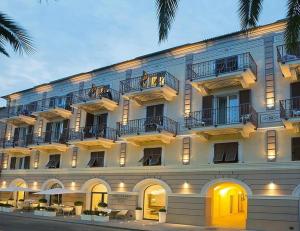 a large white building with balconies on a street at Hotel San Pietro Palace in Finale Ligure