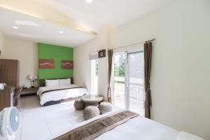 een slaapkamer met 2 bedden en groene muren bij Be my house in Magong