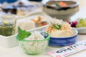una tavola ricoperta di ciotole di cibo su un piatto di Guest House YAMATOSO a Ito