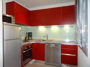 カンヌにあるLe Vieux Port Apartmentsの赤いキッチン(シンク、冷蔵庫付)