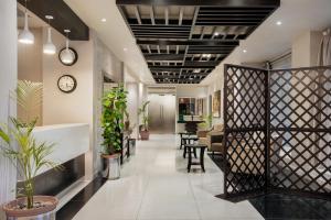 an office lobby with plants and a clock on the ceiling at Ramada by Wyndham Karachi Creek in Karachi