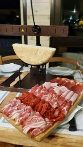 a plate of meat and bacon on a table at Gîte Chalet du Soulor in Arrens-Marsous