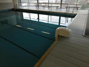 a swimming pool in a building with a view of the water at Schönes Apartment mit Pool&Sauna in Bingen am Rhein