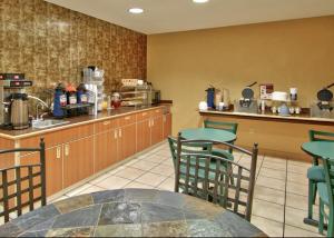una cocina con mesa y sillas en un restaurante en Western Skies Inn & Suites, en Los Lunas