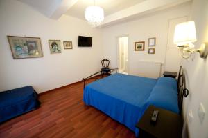 1 dormitorio con 1 cama azul y suelo de madera en Suite Argentina, en Roma