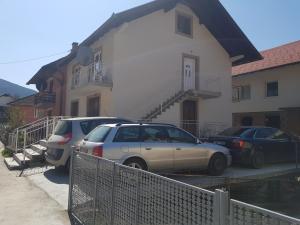 two cars parked in front of a house at Apartman Lara 2 in Foča