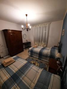 1 Schlafzimmer mit 2 Betten und einem Kronleuchter in der Unterkunft Maison Donatello in Valeggio sul Mincio