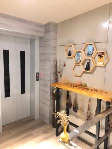 een kamer met een tafel en een muur met spiegels bij YY Elleys Home in Jiaoxi