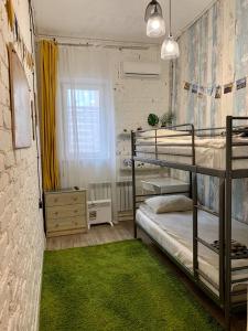 a bedroom with two bunk beds and a green rug at Neptunea Apartments in Vladivostok