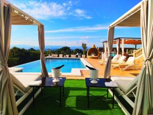 a villa with a view of a pool and two chairs at Villa Versace súper lujo 14 huéspedes + invitados in Palma de Mallorca