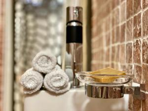 un lavandino in bagno con asciugamani e una bottiglia di sapone di Èrsextius, GGB1, Aix-en-Provence ad Aix en Provence Altre 25 foto