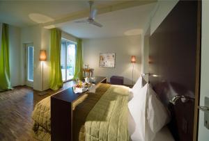 1 dormitorio con 1 cama grande en una habitación en Weingartenhotel Harkamp Südsteiermark, en Sankt Nikolai im Sausal