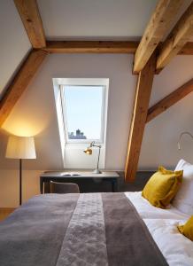 Un dormitorio con una cama grande y una ventana en Sorell Hotel Seefeld en Zúrich