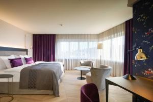チューリッヒにあるソレル ホテル ゼーフェルトのベッドとデスクが備わるホテルルームです。