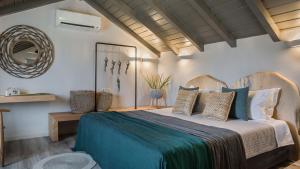 a bedroom with a large bed with a blue blanket at Avithos Resort Hotel in Svoronata